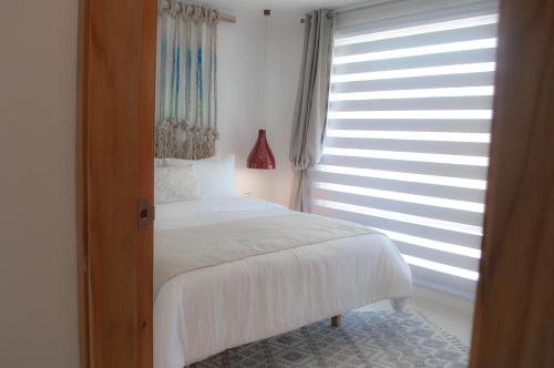 a bedroom with a white bed and a window at Sabbia By LD Hoteles in El Roque