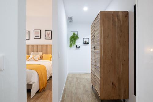 sypialnia z łóżkiem i drewnianą komodą w obiekcie Dorm4You Arena Family 13 w Walencji