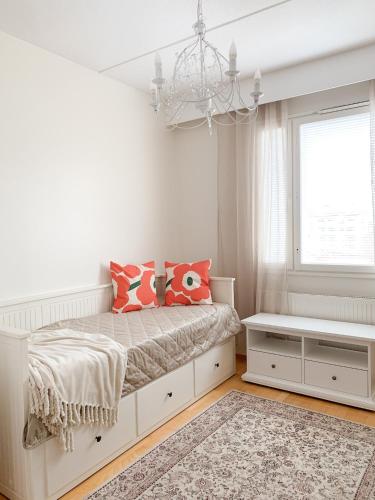 - une chambre blanche avec un lit et un lustre dans l'établissement Rovaniemi City Centre Apartment, private sauna, à Rovaniemi