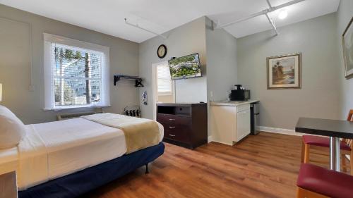 a bedroom with a bed and a desk and a kitchen at Crystal Bay Historic Hotel in St Petersburg
