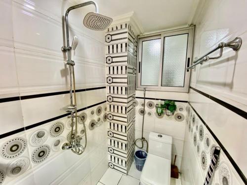 baño blanco con ducha y lavamanos en Appartement meublé 2 Chambres, Salon - Bastos, Ambassade du Tchad, Yaoundé, CMR, en Mbala