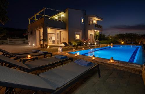 une villa avec une piscine la nuit dans l'établissement Four Seasons private villa - seaview - big heated pool - gym - sport activities, à Gouves
