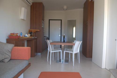 sala de estar con mesa de comedor y sillas en Rocciarossa en Isola Rossa