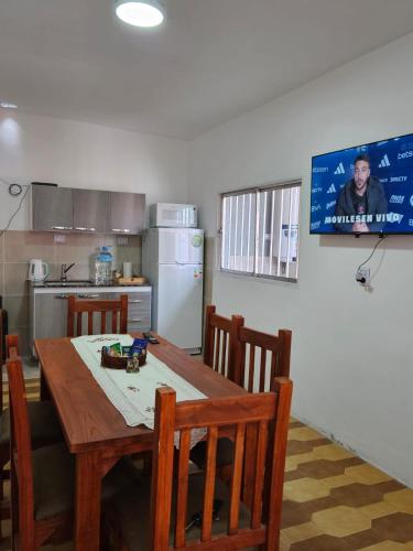 eine Küche mit einem Tisch und Stühlen sowie einem TV in der Unterkunft Casa de Mayo in Tinogasta