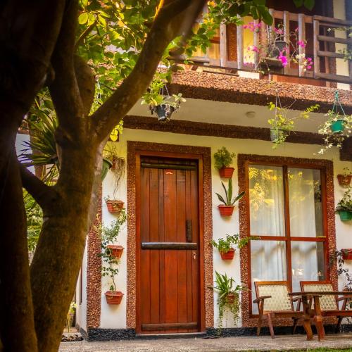 a house with a wooden door and windows at Gypsy Garden Guesthouse & Homestay in Kosgoda