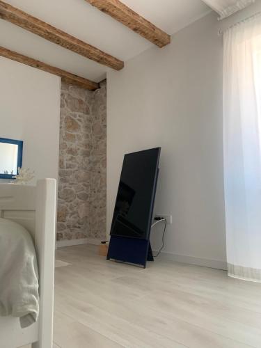 a flat screen tv sitting on the floor of a bedroom at House Franulich in Stara Baška