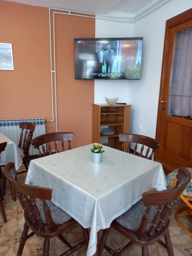 Un comedor con una mesa y sillas blancas. en Sobe Ruža, en Banjol