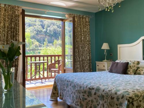 1 dormitorio con cama y vistas a un balcón en Hotel Finca Malvasia en Cabezón de Liébana