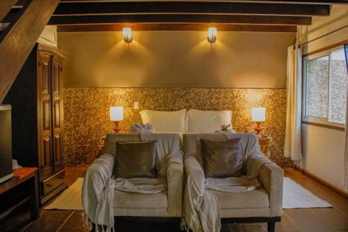 a bedroom with a bed with a couch in it at Estalagem Wiesbaden in Monte Verde