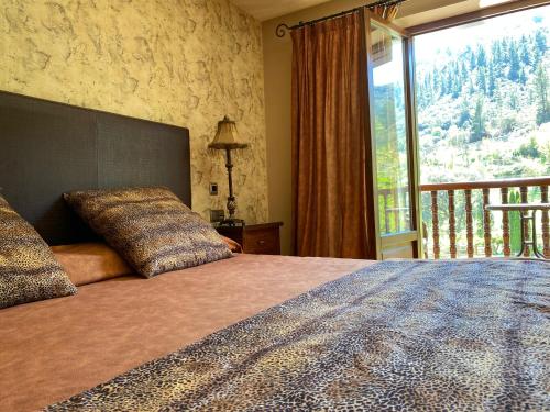 a bedroom with a large bed with a large window at Hotel Finca Malvasia - Adults only in Cabezón de Liébana