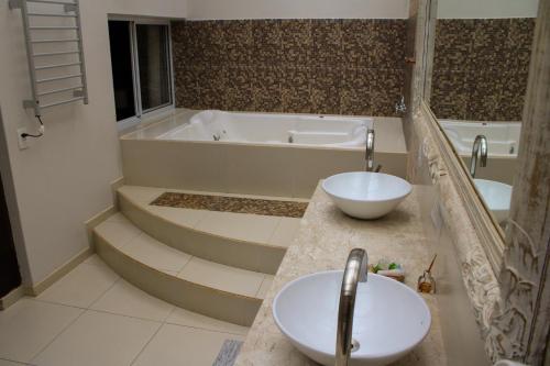 a bathroom with a tub and a sink and a tub at Estalagem Wiesbaden in Monte Verde