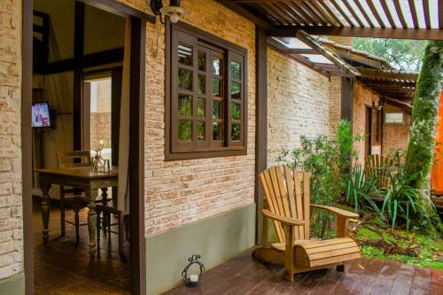 a patio with a wooden chair and a table at Estalagem Wiesbaden in Monte Verde