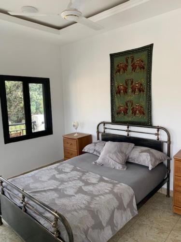 um quarto com uma cama e uma fotografia na parede em Cuckoo's Nest em Tanji
