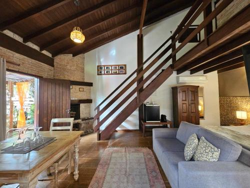 a living room with a blue couch and a table at Estalagem Wiesbaden in Monte Verde