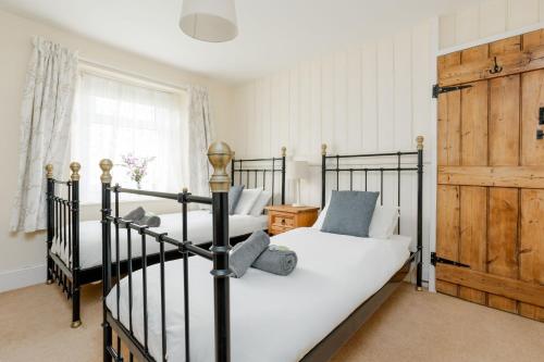 a bedroom with two bunk beds and a window at Froxfield Cottage in Langton Matravers