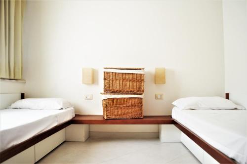 Habitación con 2 camas y mesa con cestas. en Rocciarossa en Isola Rossa