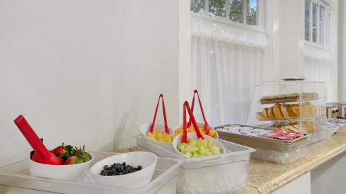 a counter with bowls of fruits and vegetables on it at Crystal Bay Historic Hotel in St Petersburg