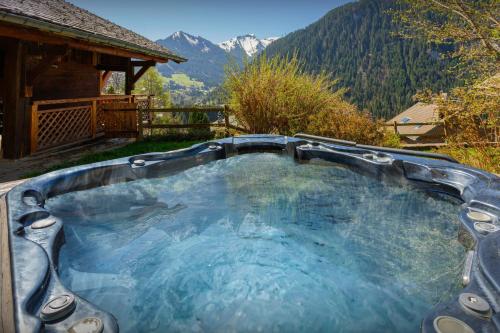 a hot tub with a view of the mountains at La Grange au Merle - OVO Network in Châtel
