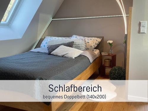 Schlafzimmer mit einem Bett mit blauer Bettwäsche und Kissen in der Unterkunft Ferienwohnung Auszeit Dachstudio in Sulzburg