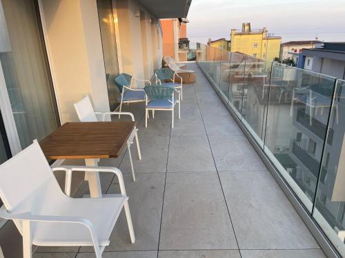 a balcony with tables and chairs on a building at Haus Margarete - Attico Infinity Vista Mare con Jacuzzi - Agenzia Cocal in Caorle