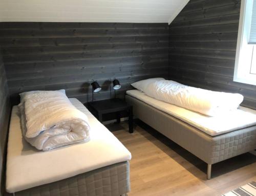 two beds in a room with a black wall at Cabin - Målselv fjellandsby in Bergset