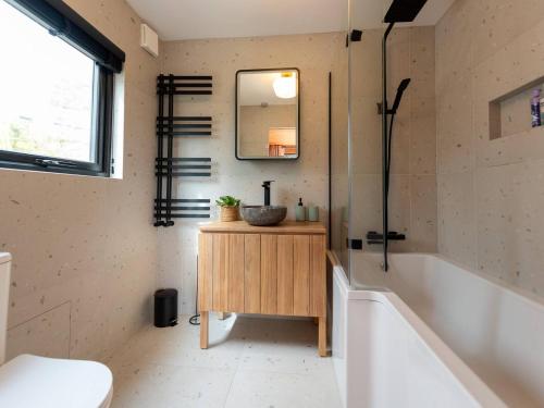 uma casa de banho com uma banheira, um lavatório e um espelho. em Pass the Keys Acorn Lodge · Luxury Retreat In a Stunning Oasis With Hot Tub em Market Drayton