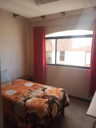 um quarto com uma cama e uma grande janela em Aidee em La Paz