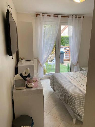 une chambre avec un lit, une télévision et une fenêtre dans l'établissement chambre avec entrée indépendante situation idéale, à Serris