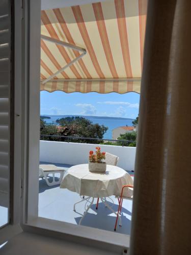 Un balcón con mesa y vista al mar. en Sobe Ruža, en Banjol