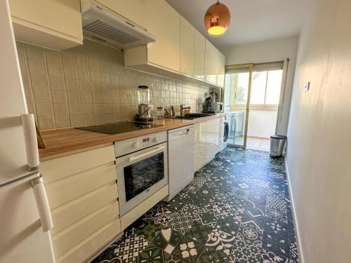 Il comprend une cuisine équipée d'une cuisinière et d'un lave-vaisselle. dans l'établissement Emplacement idéal à 500m du Palais, 2P fonctionnel, à Cannes