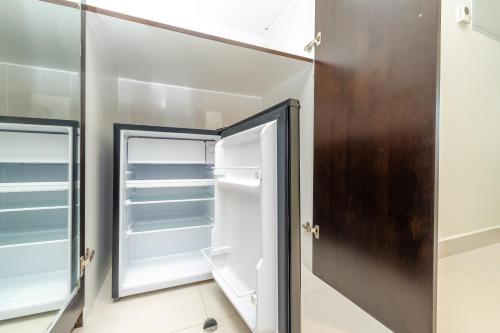 a kitchen with an open refrigerator and a mirror at King Bed Condo in Dubai Sports City with Pool, Sauna, Fast Wi-Fi in Dubai