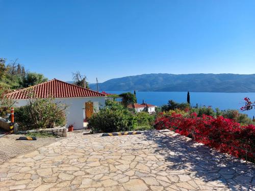a stone walkway with flowers and a view of the water at Villa Tramonto in Lévki
