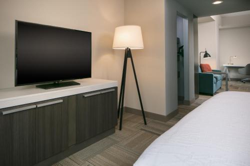 a hotel room with a flat screen tv on a cabinet at Hilton Garden Inn Iowa City Downtown University in Iowa City