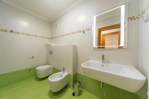 un bagno bianco con lavandino e WC di Garden Palace Pool Deluxe Apartment a Umag (Umago)