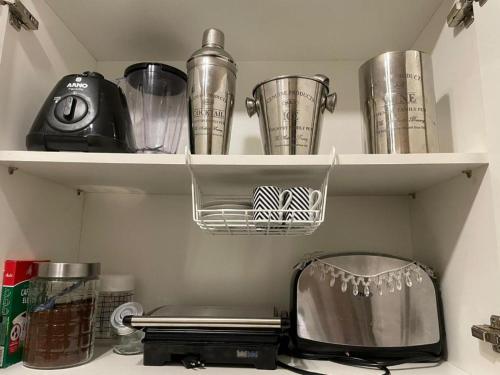 a kitchen shelf with cups and a toaster at BeM Ipanema in Rio de Janeiro