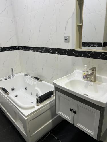 uma casa de banho com uma banheira branca e um lavatório. em 3Bedroom Serviced Apartment Shortlet, Lekki- Lagos em Lekki