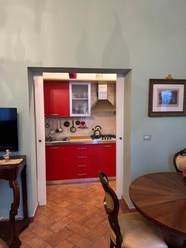 une cuisine avec des placards rouges et une table en bois dans l'établissement Centro storico Residenza di charme, à Rimini