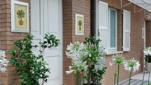 a house with white flowers in front of a door at Aura Relais in Numana