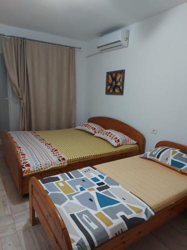 2 bedden in een kamer met 3 stoelen en 3 stoelen. bij CASA DALYS in Orşova