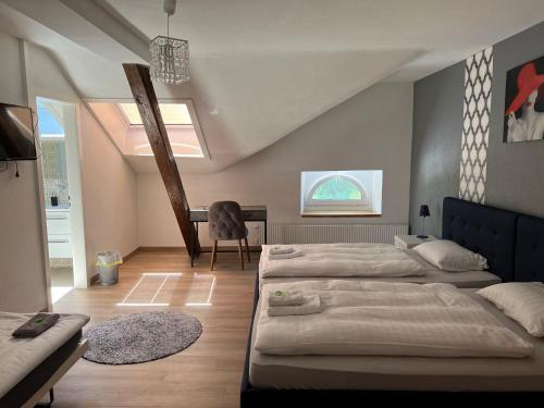 a bedroom with two beds and a desk in it at Hotel Restaurant du Moulin in Fleurier