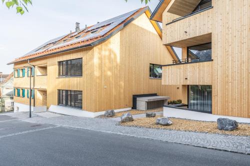 a wooden house with a fireplace in front of it at Alpen Krone by Maier - Dornbirn in Dornbirn