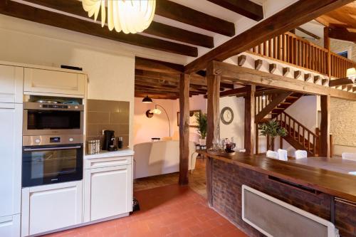 une cuisine avec des placards blancs et un comptoir en briques dans l'établissement Le Haut Bois - 14 personnes à 5 min du Zoo et centre ville - 1 appartement en dépendance, à Saint-Aignan