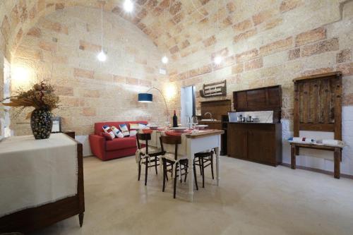 a kitchen and living room with a table and chairs at Casina Li Fumareddhi in Corsano