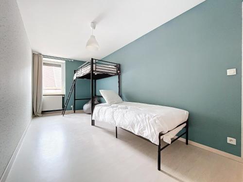 - une chambre avec des lits superposés et un mur bleu dans l'établissement grand appartement centre-ville, à Clairvaux-les-Lacs