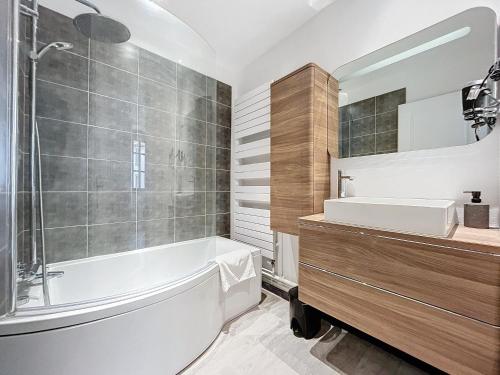 une salle de bain avec une baignoire et un lavabo dans l'établissement grand appartement centre-ville, à Clairvaux-les-Lacs