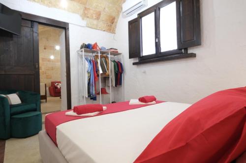 a bedroom with a large bed with red and white sheets at Casina Li Fumareddhi in Corsano