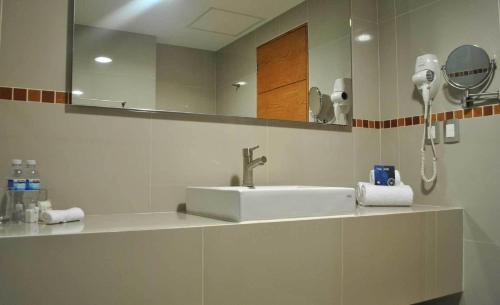 W łazience znajduje się umywalka i lustro. w obiekcie Hotel y Tú Expo w mieście Guadalajara