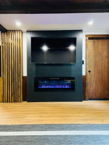 a living room with a fire place in the wall at NEW! Cozy & Modern A-Frame in the woods w/HOT TUB in Tamworth