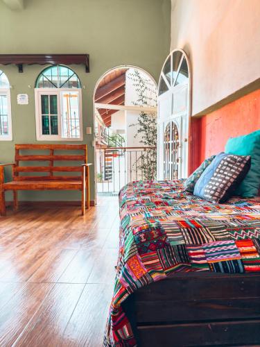 ein Schlafzimmer mit einem Bett und einer Bank darin in der Unterkunft Casa Sunset in Flores