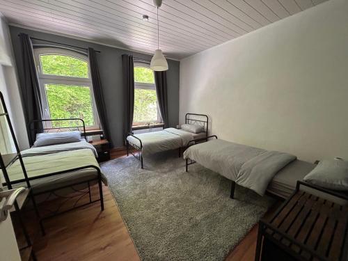 two beds in a room with two windows at Ferienwohnung Obernahmer in Hagen